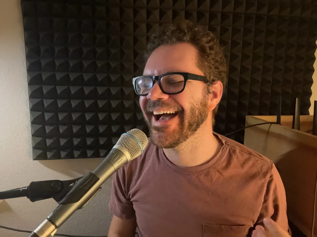 Dakota Lee Martinez singing into a microphone in his home studio